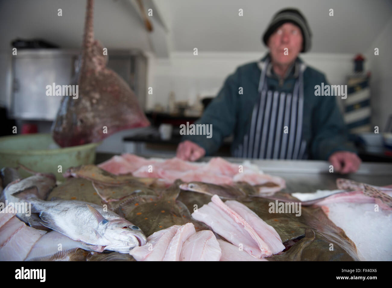 Venditore di pesce o pescivendolo a una piccola presa vicino al mare di Hastings, East Sussex, Inghilterra, Regno Unito. Foto Stock