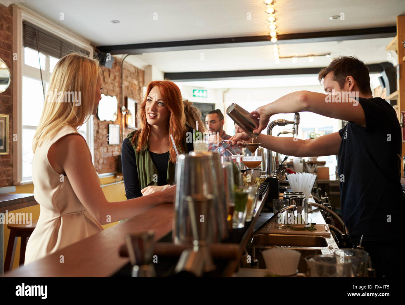 Amici di sesso femminile godersi drink nel Cocktail Bar Foto Stock