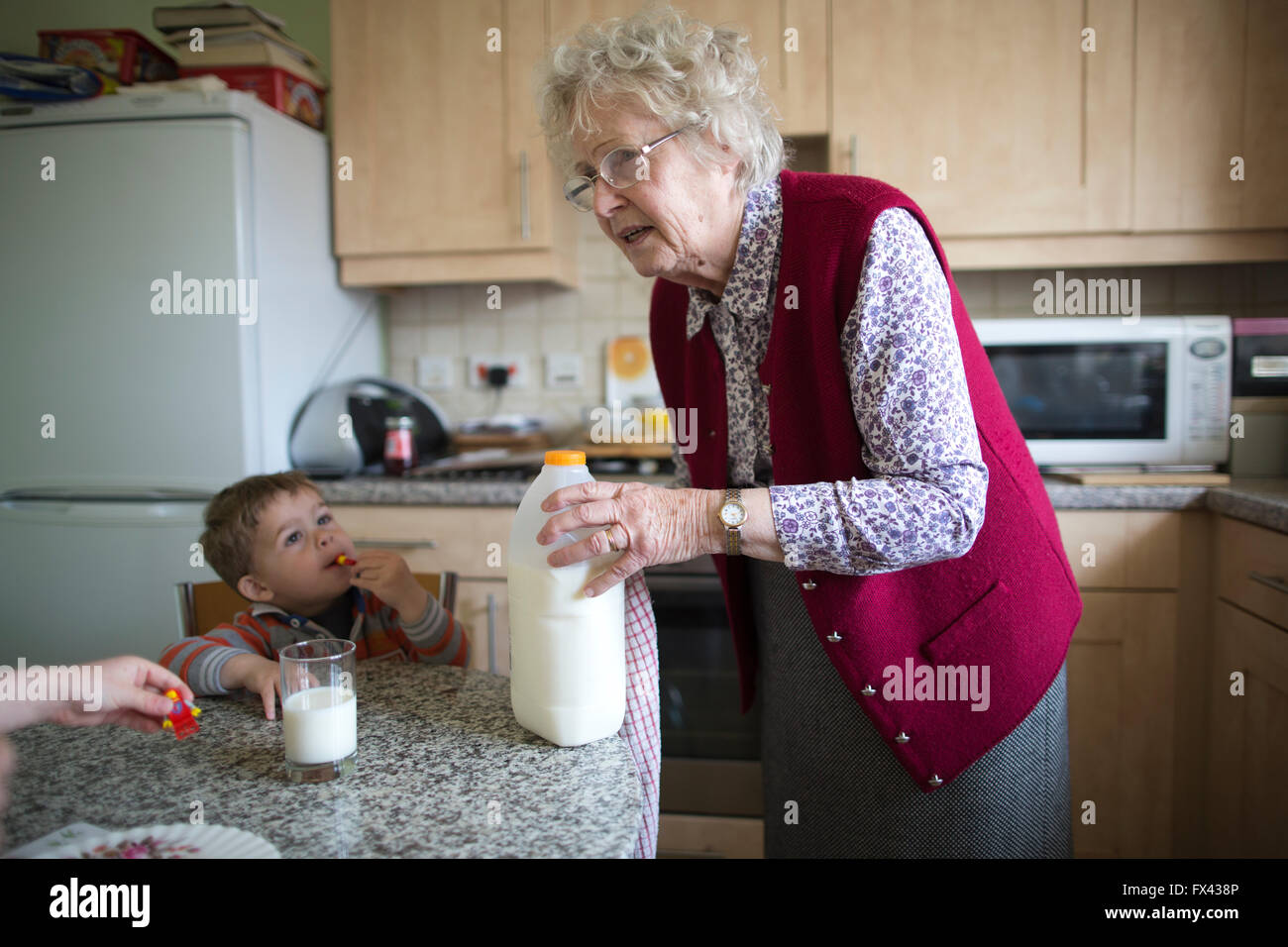 Titolare di pensione o di rendita anziani (età 80) cura dei suoi nipoti (di età compresa tra 2 e 5), a casa nel Dorset, England, Regno Unito Foto Stock