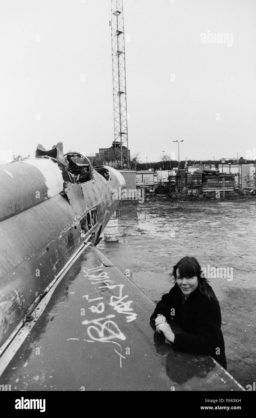 Archivio di immagine di una giovane donna appoggiata sul parafango del Mig sovietici-21 fighter, Mutoid Waste Company installazione artistica di Kolja Kugler, Potsdamer Platz, Berlin, Germania, marzo 1994. Modello di rilascio disponibili. Foto Stock