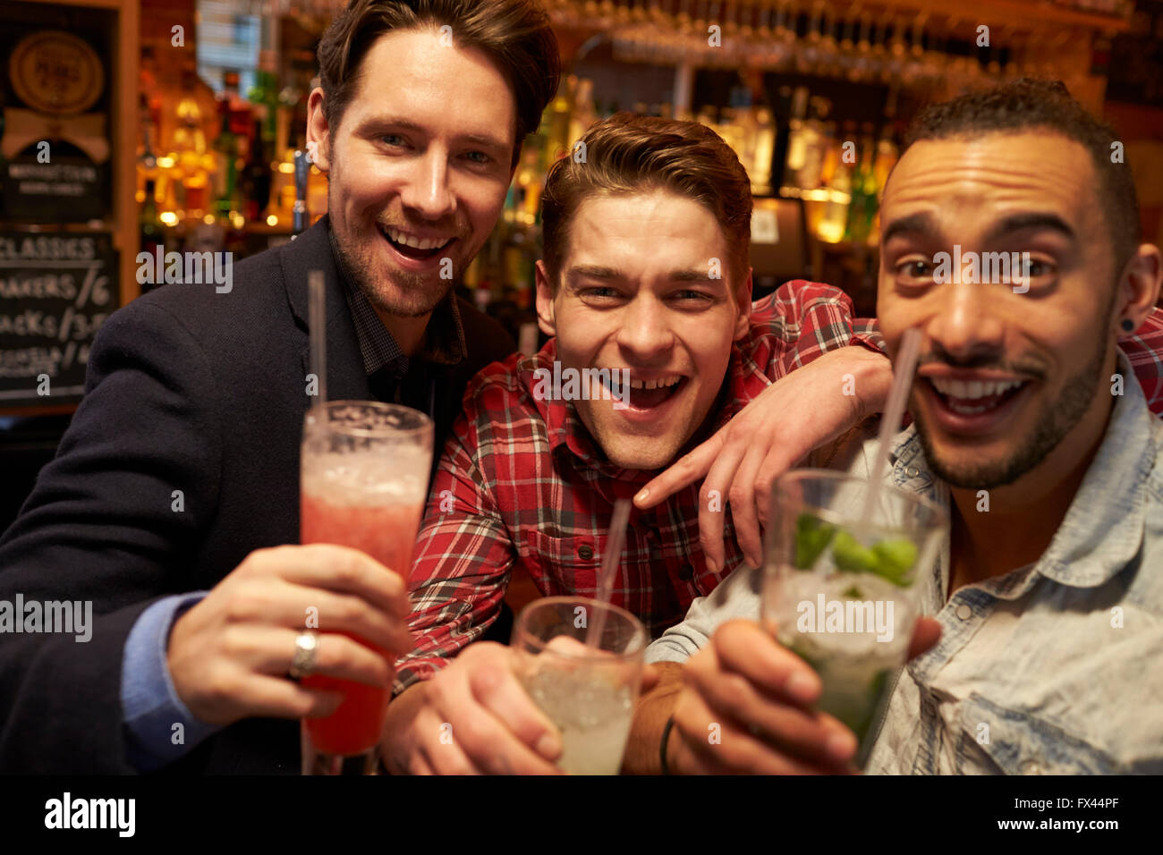 Maschio incontro gli amici per un drink serale nel Cocktail Bar Foto Stock