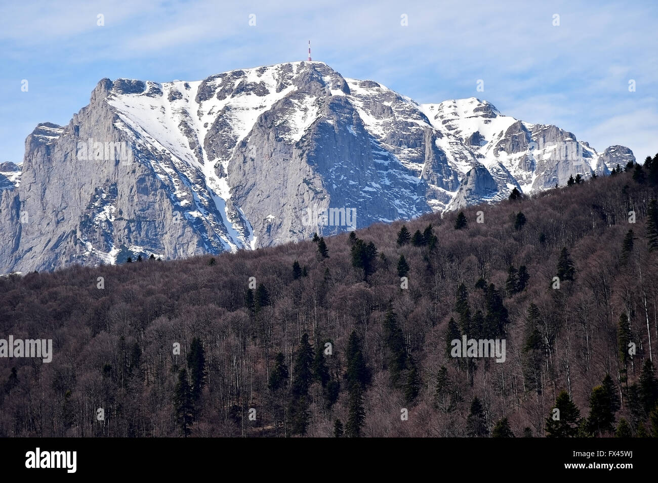 Montagne di Bucegi in inverno con gli eroi Monumento a croce sulla sommità del picco di Caraiman. La Croce è dedicato per il rumeno di eroi Foto Stock