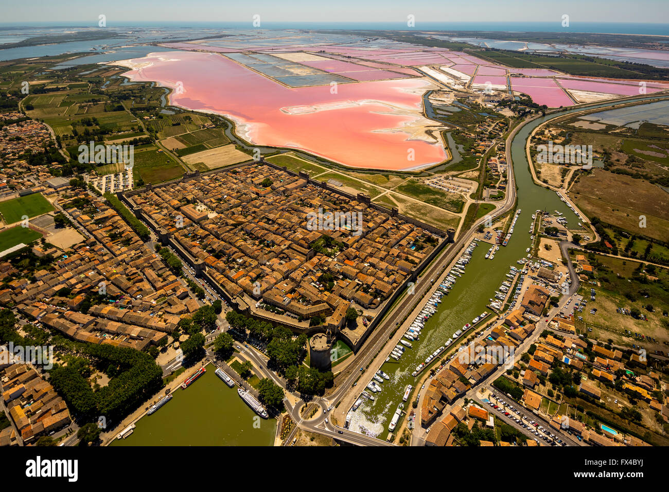 Vista aerea, centro storico La città fortificata di Aigues-Mortes, con il rosso sale laghi, di estrazione del sale, le porte della città, Camargue, Foto Stock