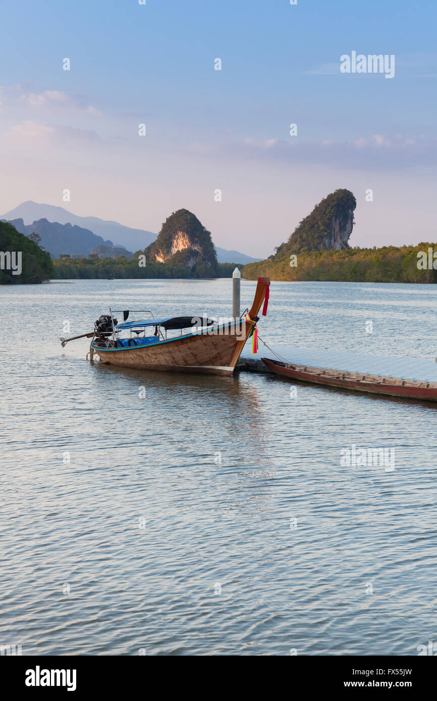 Vista al tramonto del fiume di Krabi con barca long-tail e calcare scogliere carsiche, Krabi town, Thailandia Foto Stock
