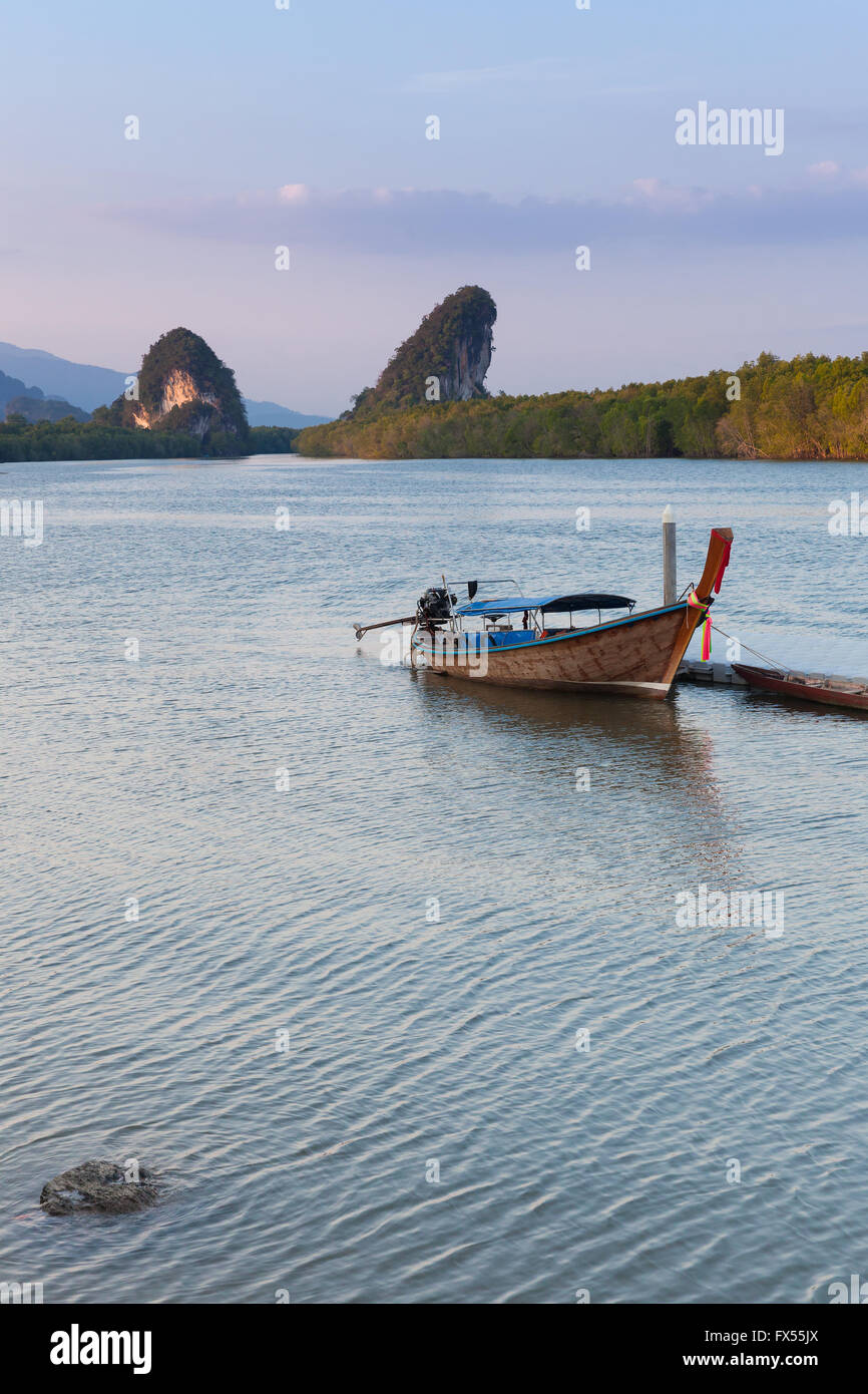 Vista al tramonto del fiume di Krabi con barca long-tail e calcare scogliere carsiche, Krabi town, Thailandia Foto Stock