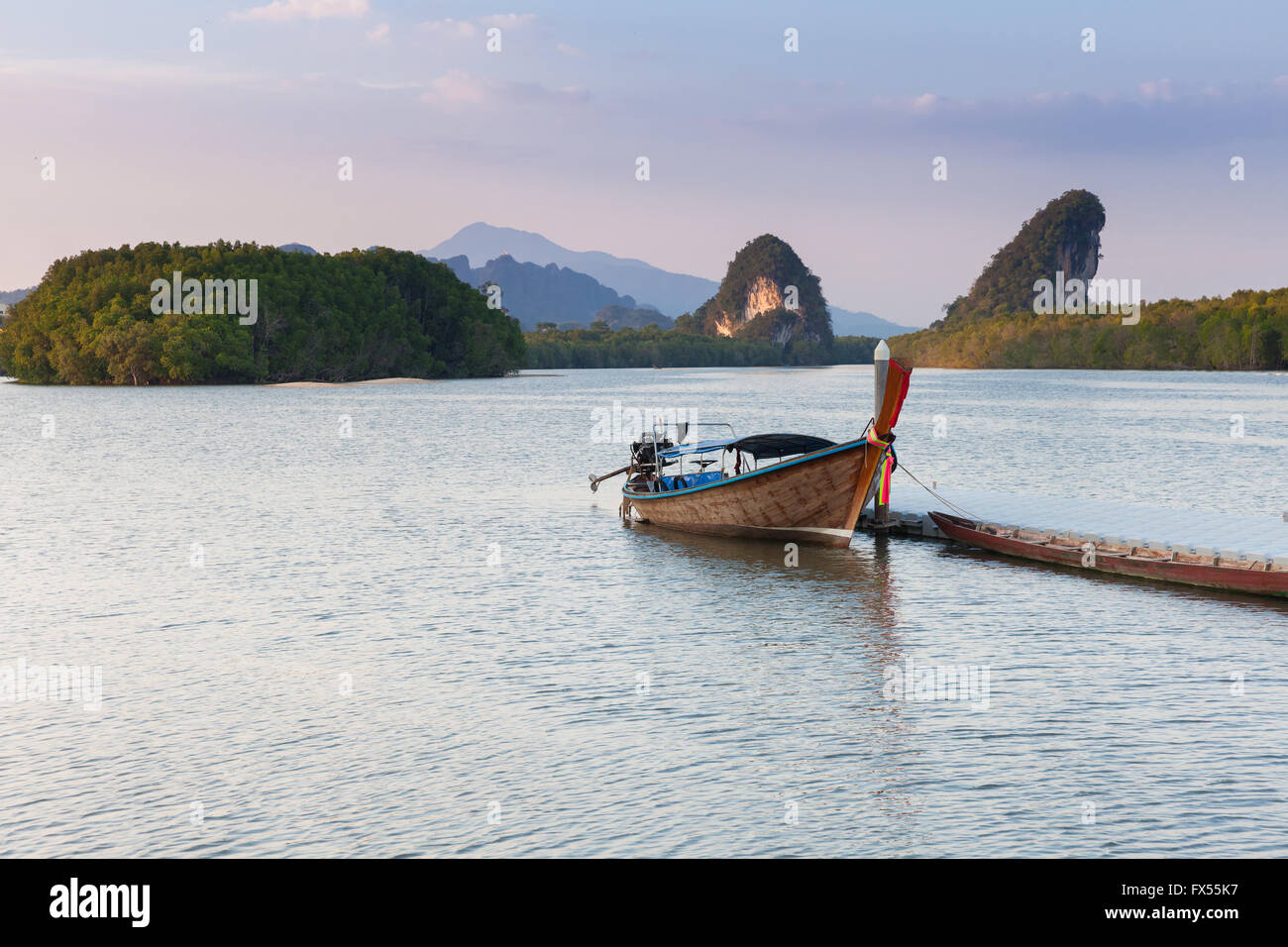 Vista al tramonto del fiume di Krabi con barca long-tail e calcare scogliere carsiche, Krabi town, Thailandia Foto Stock