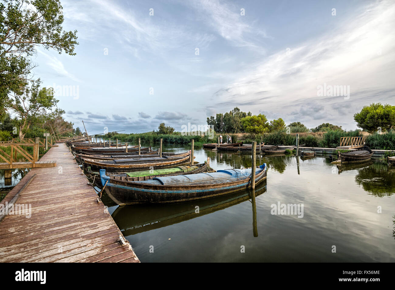 Barche ormeggiate in un porto della laguna al tramonto Foto Stock