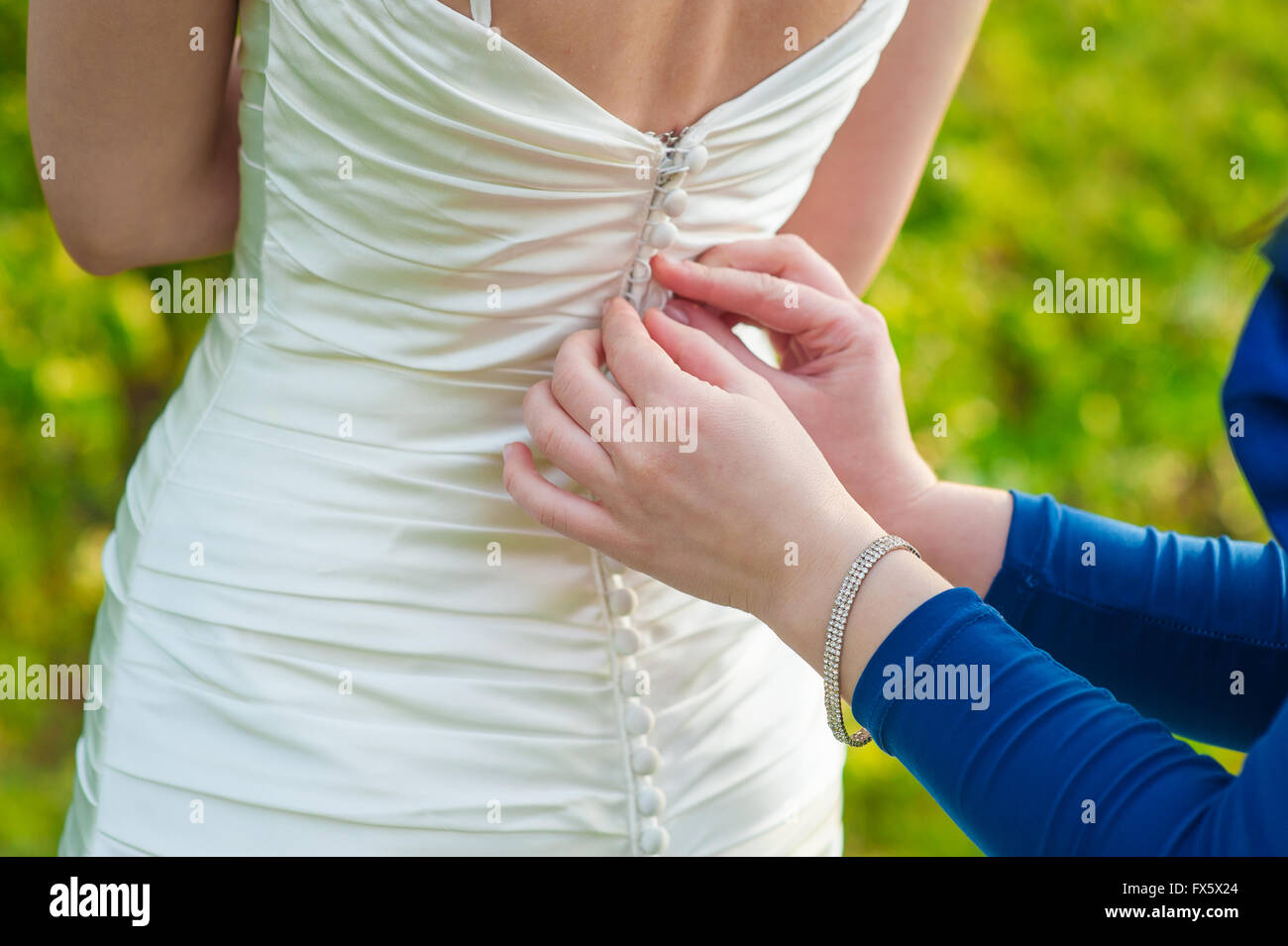 Damigella sta aiutando la sposa per vestire in weddihg giorno Foto Stock
