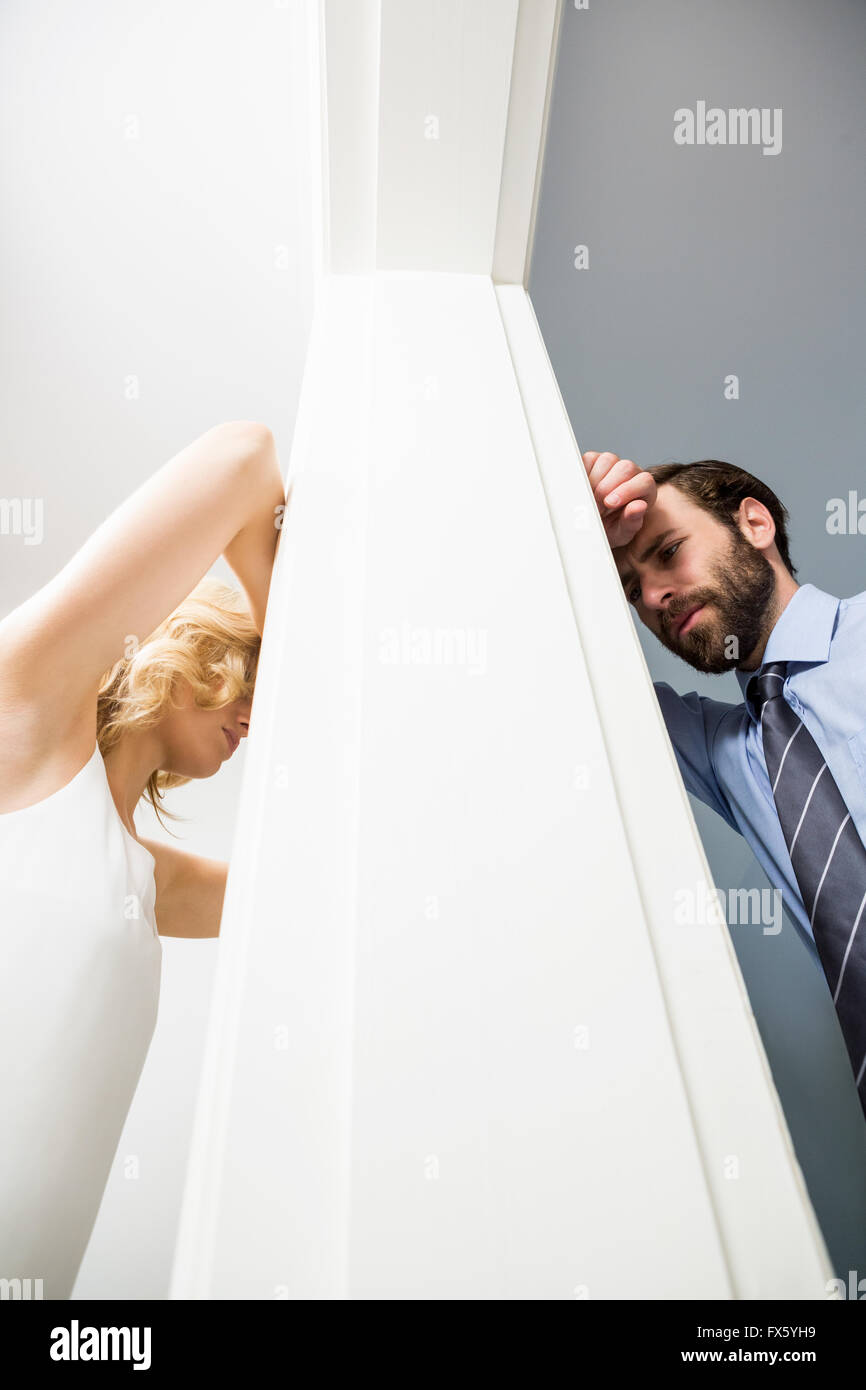 Sconvolto giovane in piedi su lati opposti della parete Foto Stock