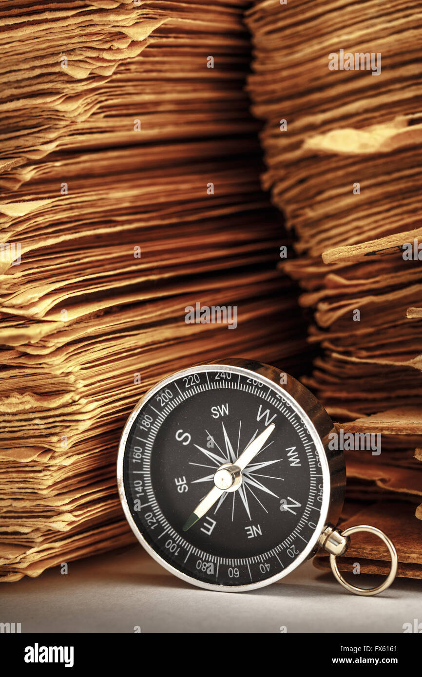 Pila di carte antiche con bussola in primo piano Foto Stock
