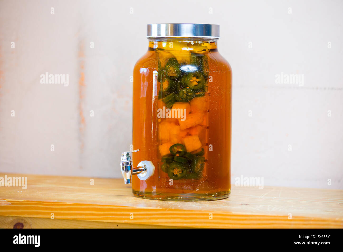 Tequila infusi con i peperoncini jalapeno in un vaso di tè presso un ristorante bar. Foto Stock