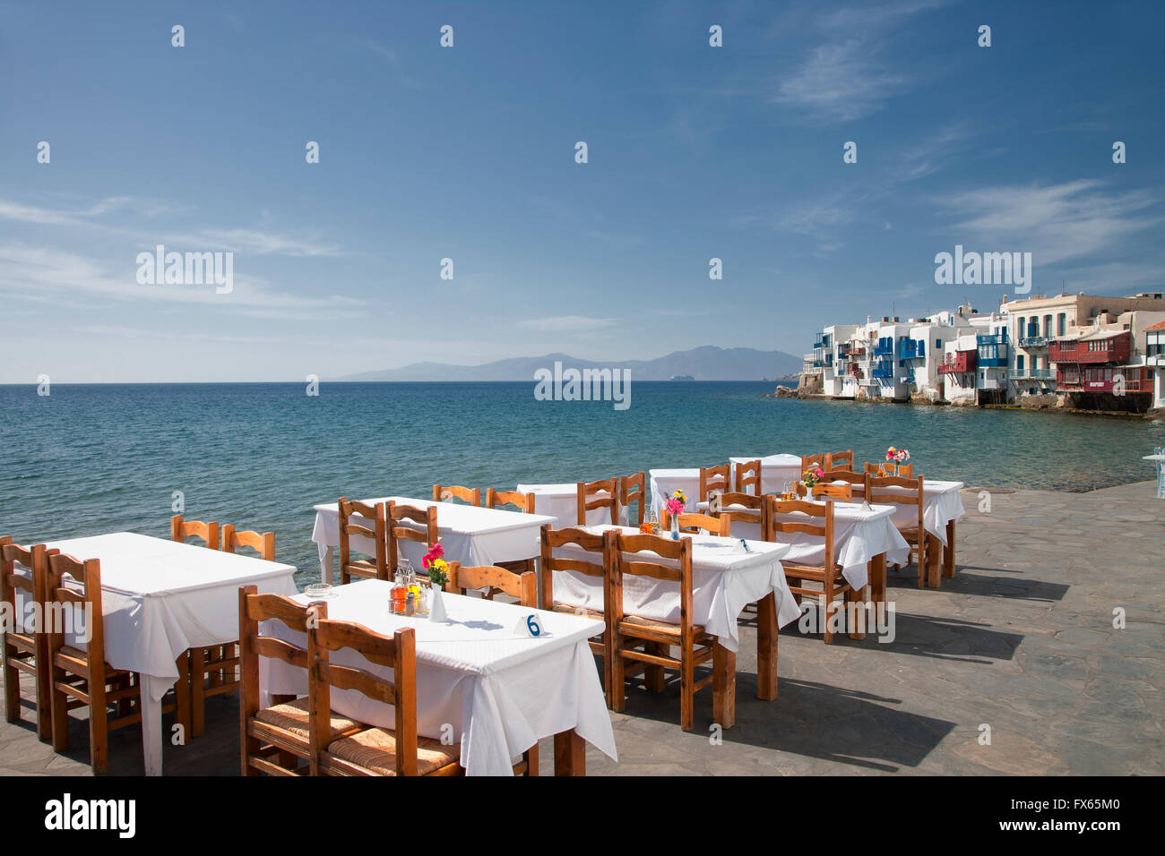 Le tabelle a waterfront cafe sotto il cielo blu Foto Stock