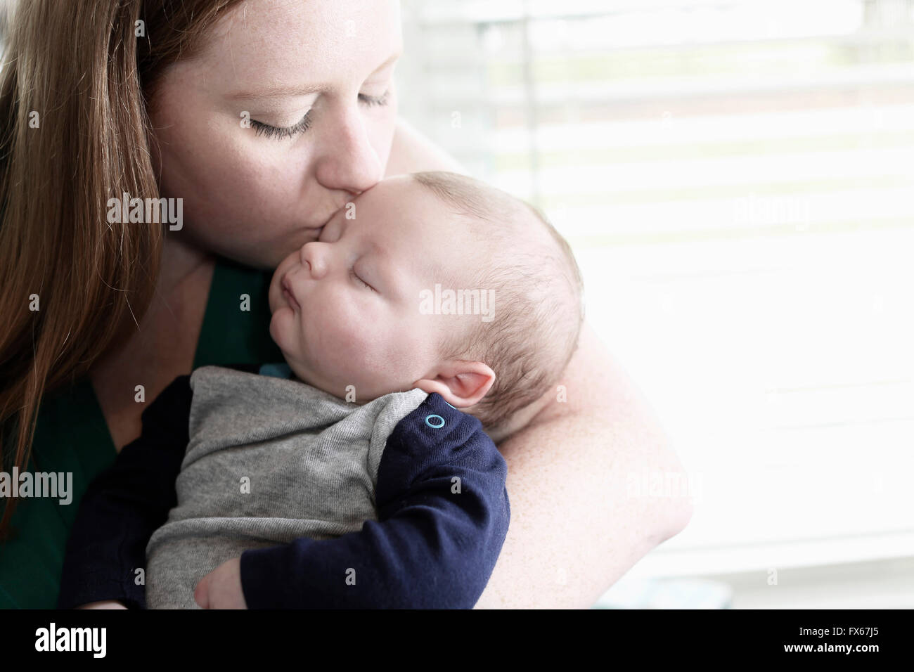 Madre kissing baby figlio Foto Stock
