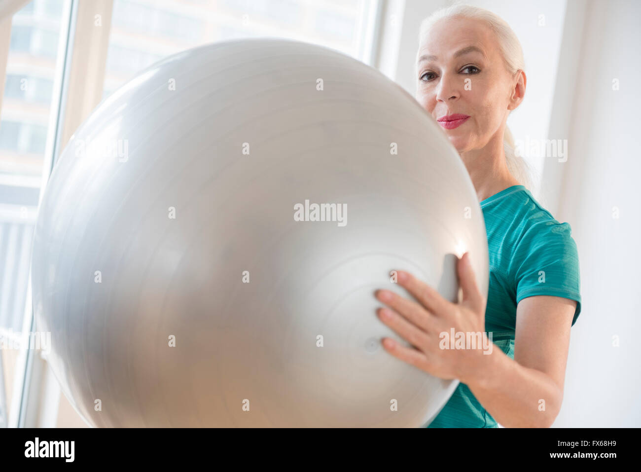 La donna caucasica tenendo palla fitness Foto Stock
