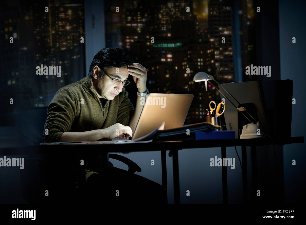 Razza mista imprenditore lavora fino a tardi in ufficio Foto Stock