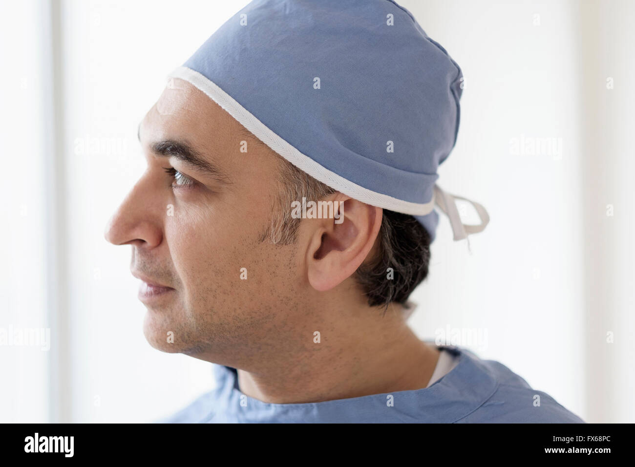 Razza mista chirurgo indossando scrubs Foto Stock