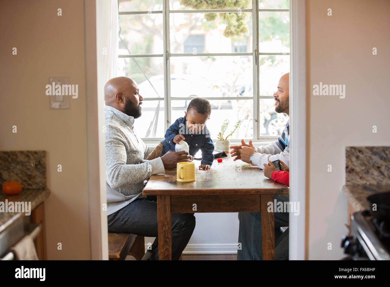 I padri e i bambini seduti a tavola Foto Stock