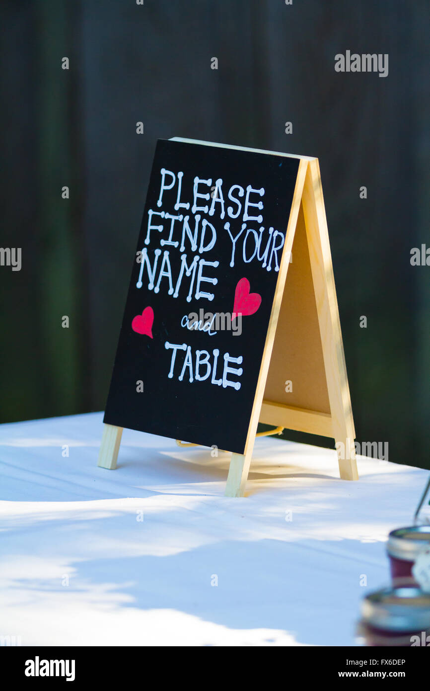 Tavoli reception hanno una disposizione dei tavoli e questo segno dice si prega di trovare il vostro nome e il vostro tavolo. Foto Stock