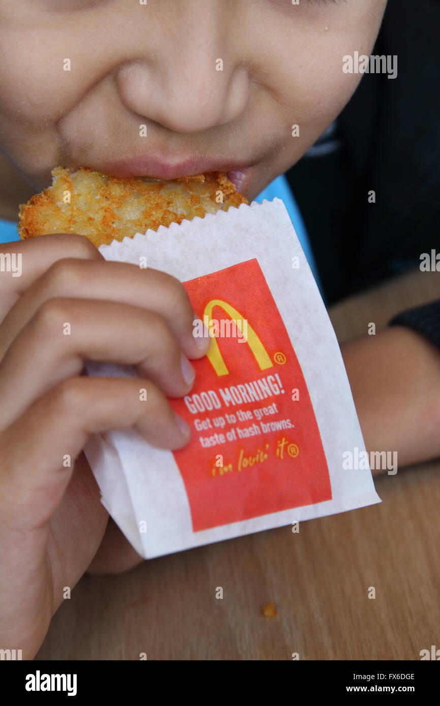 Un bambino mangiare McDonald's Hash Browns golden potato Foto Stock
