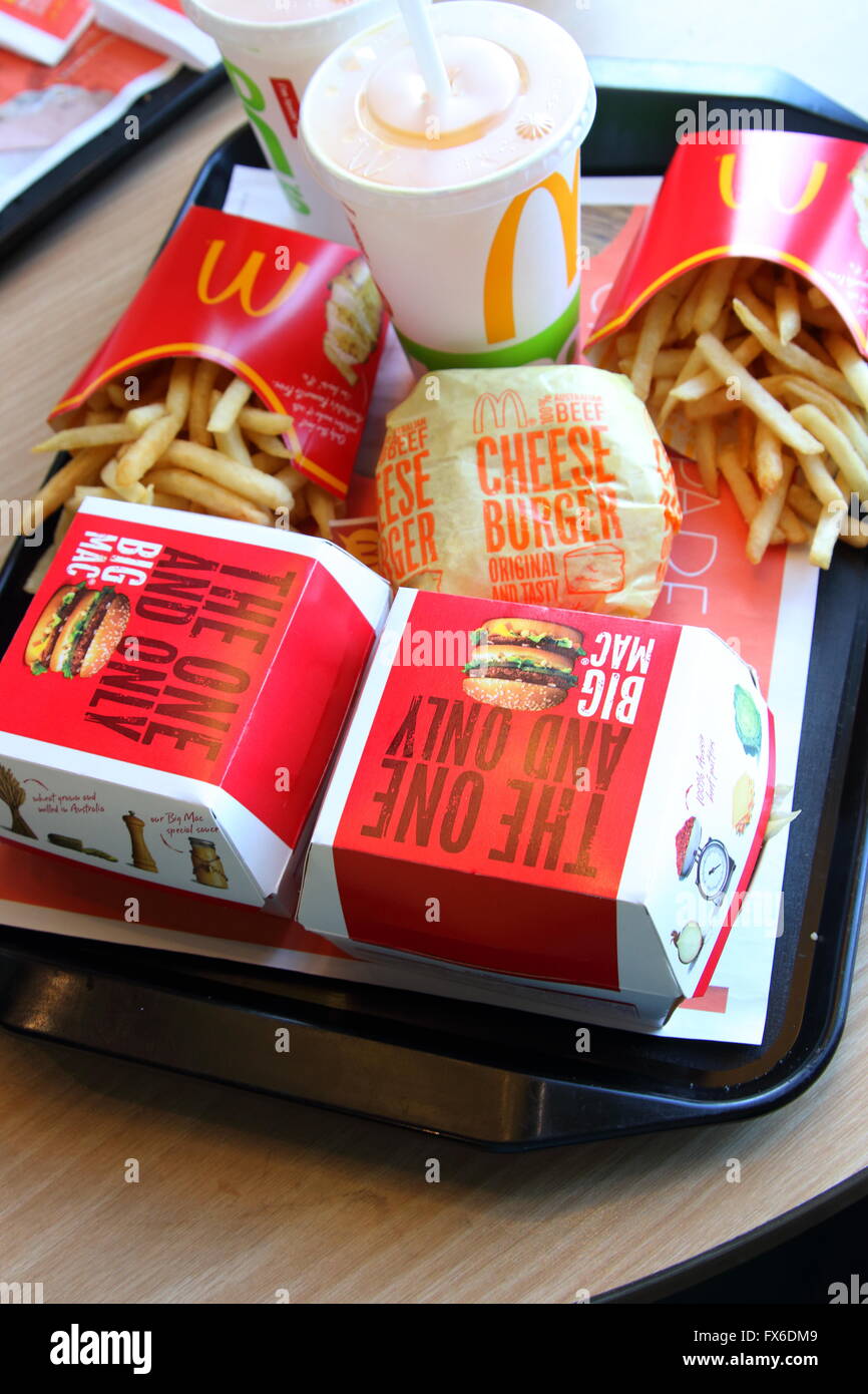 McDonald's pasto - Big Mac e formaggio hamburger, patatine fritte e bere sul vassoio di plastica Foto Stock