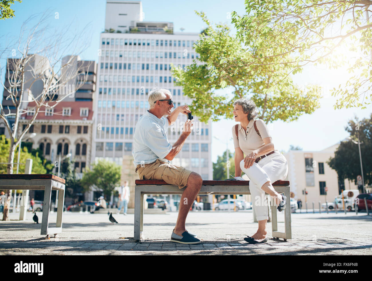 Uomo senior di scattare le foto della sua moglie. Coppia matura divertirsi sulla loro vacanza. Foto Stock