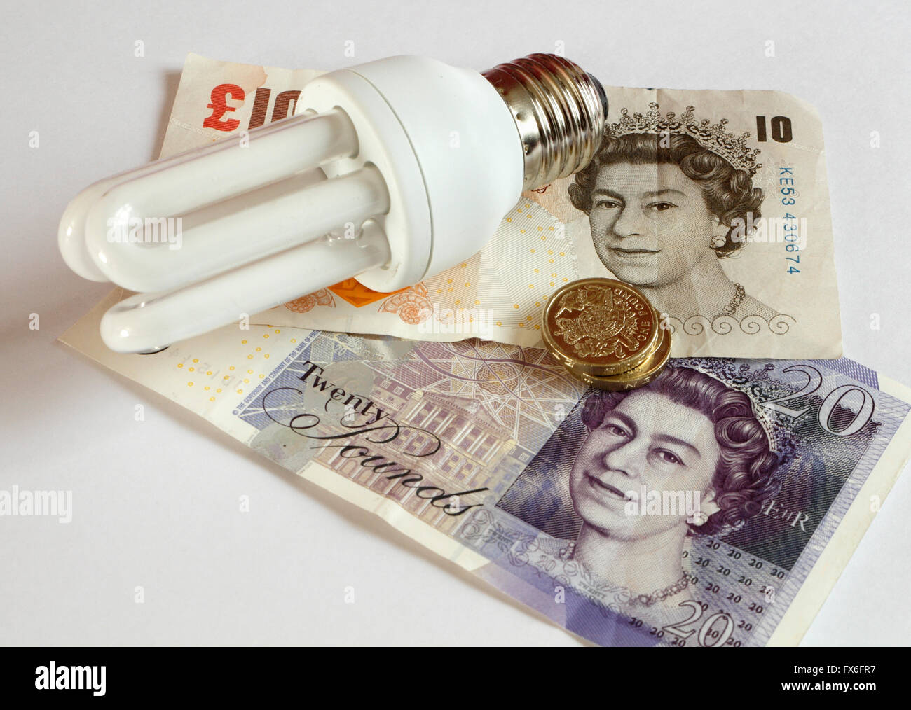 Lampadina a risparmio energetico, con banconote in denaro, efficienza energetica, basse emissioni di carbonio Foto Stock