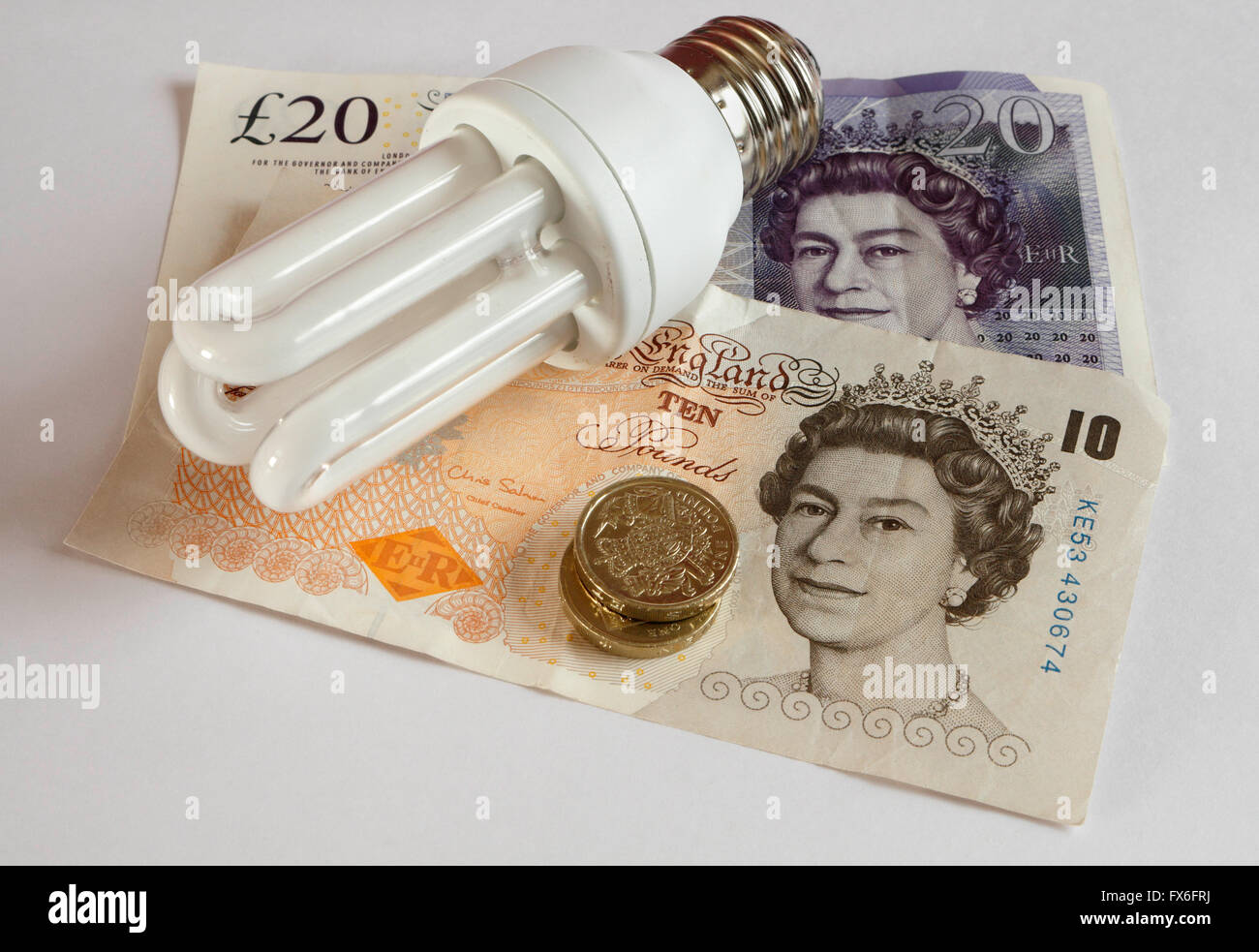 Lampadina a risparmio energetico, con banconote in denaro, efficienza energetica, basse emissioni di carbonio Foto Stock