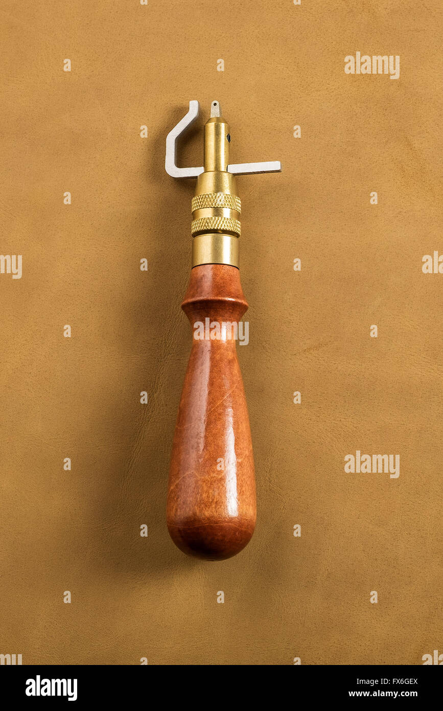 Scanalatore cucitura con manico in legno sulla pelle marrone Foto Stock