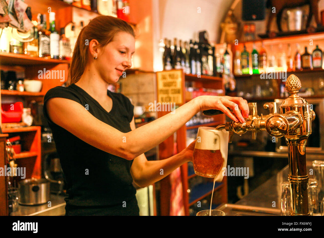 Bar di Praga a Mala strana giovane cameriera che serve birra, bar 'U Zavesenyho kafe Praga Repubblica Ceca birra pinta di spillatura Foto Stock