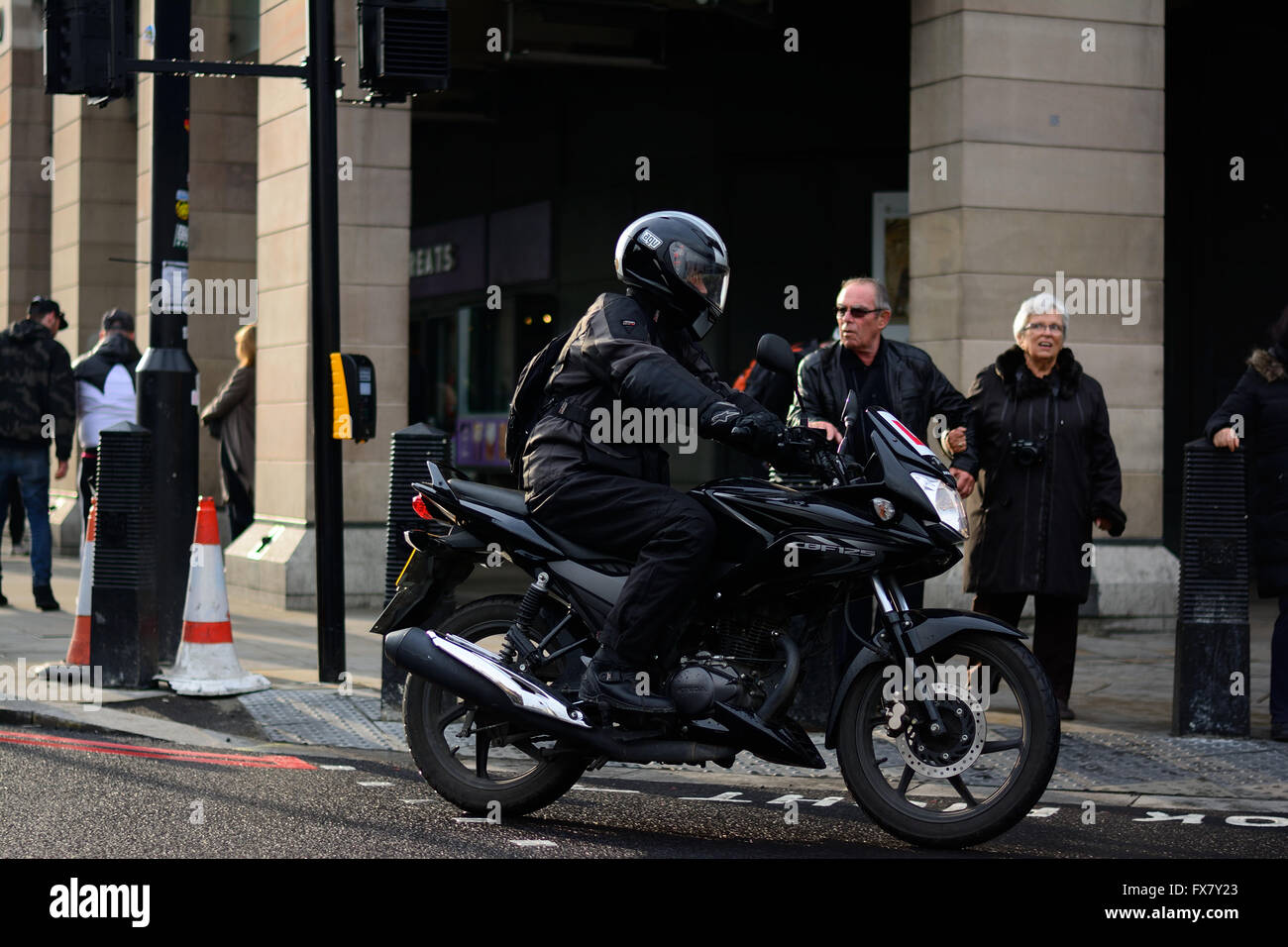 Motociclista andando ad angolo arrotondato a Londra Foto Stock
