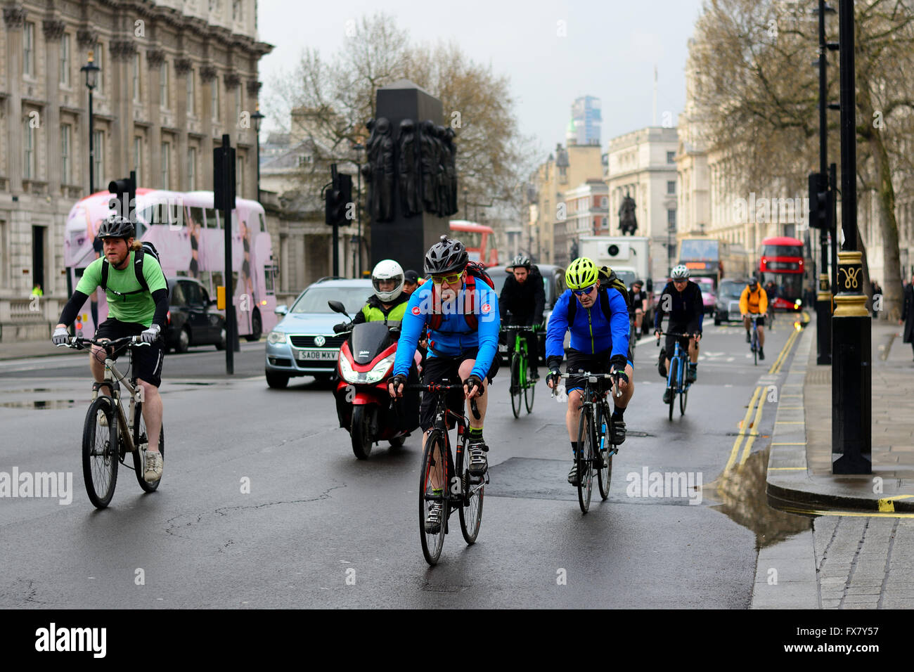 I ciclisti in sella per le strade di Londra in condizioni di bagnato Foto Stock