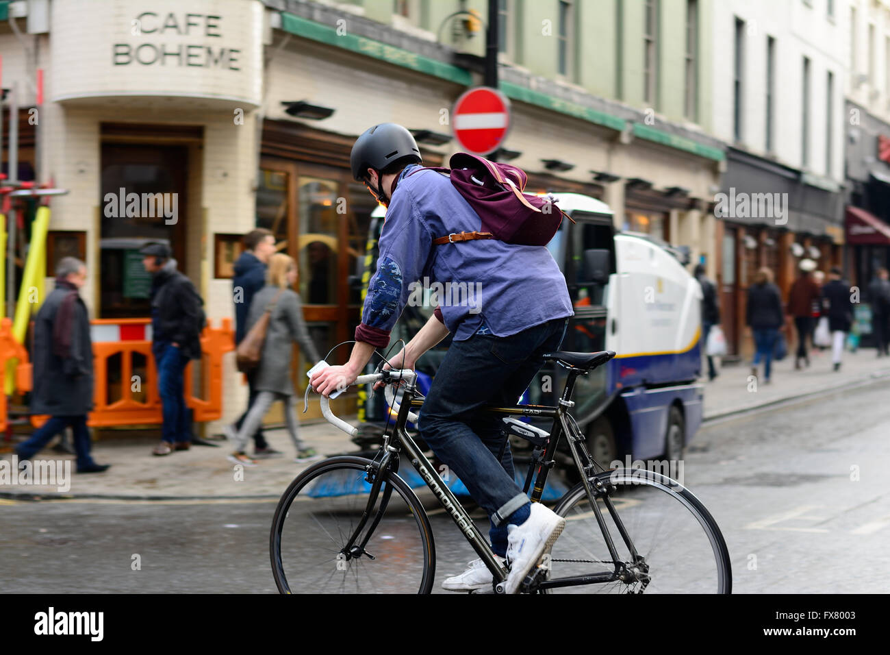 Ciclista correre lungo il percorso di spazzamento strade veicolo in Londra Foto Stock