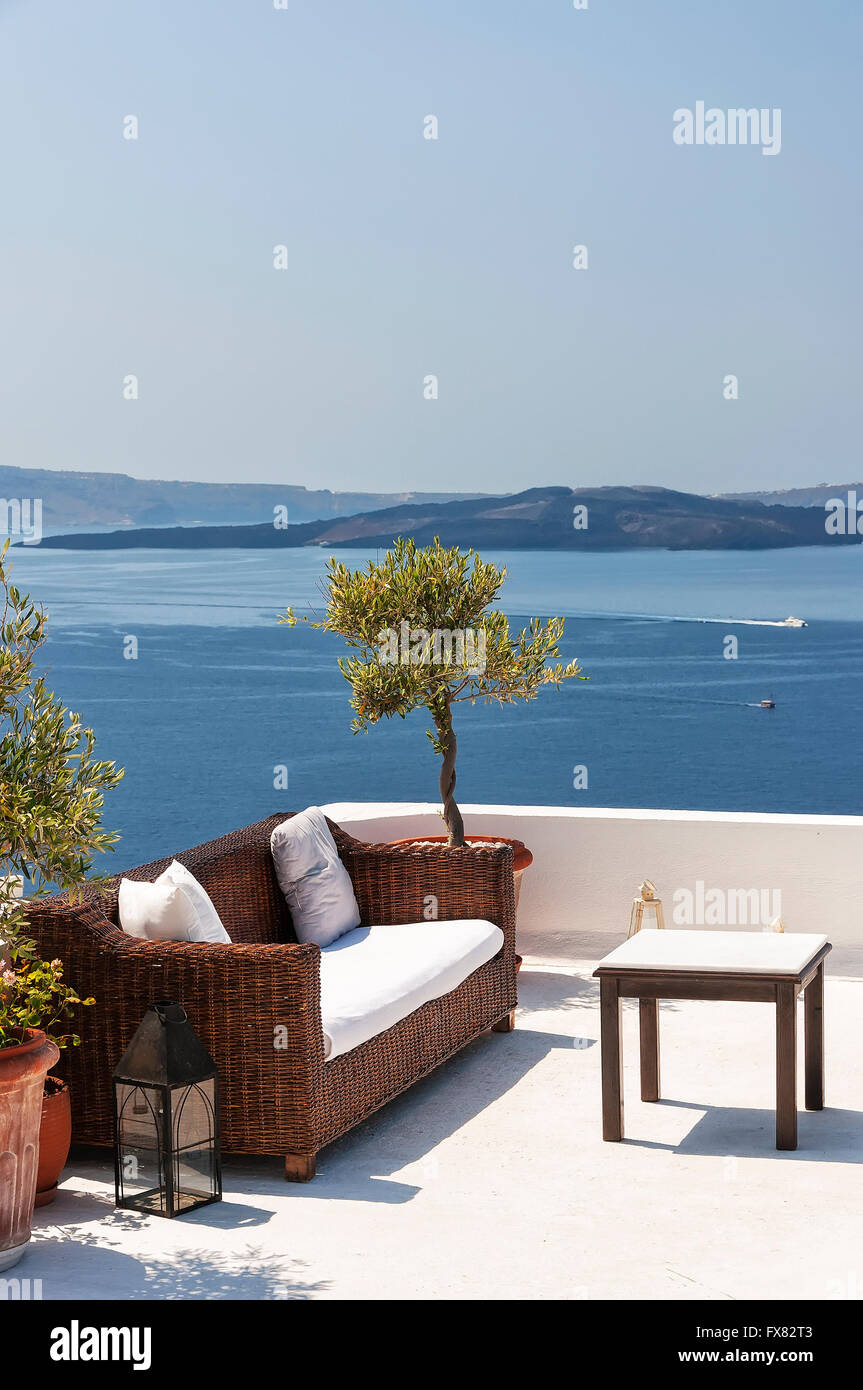 Tavolo esterno e divani sulla terrazza che si affaccia sul mare, villaggio di Oia - Santorini, Cicladi Grecia. Foto Stock