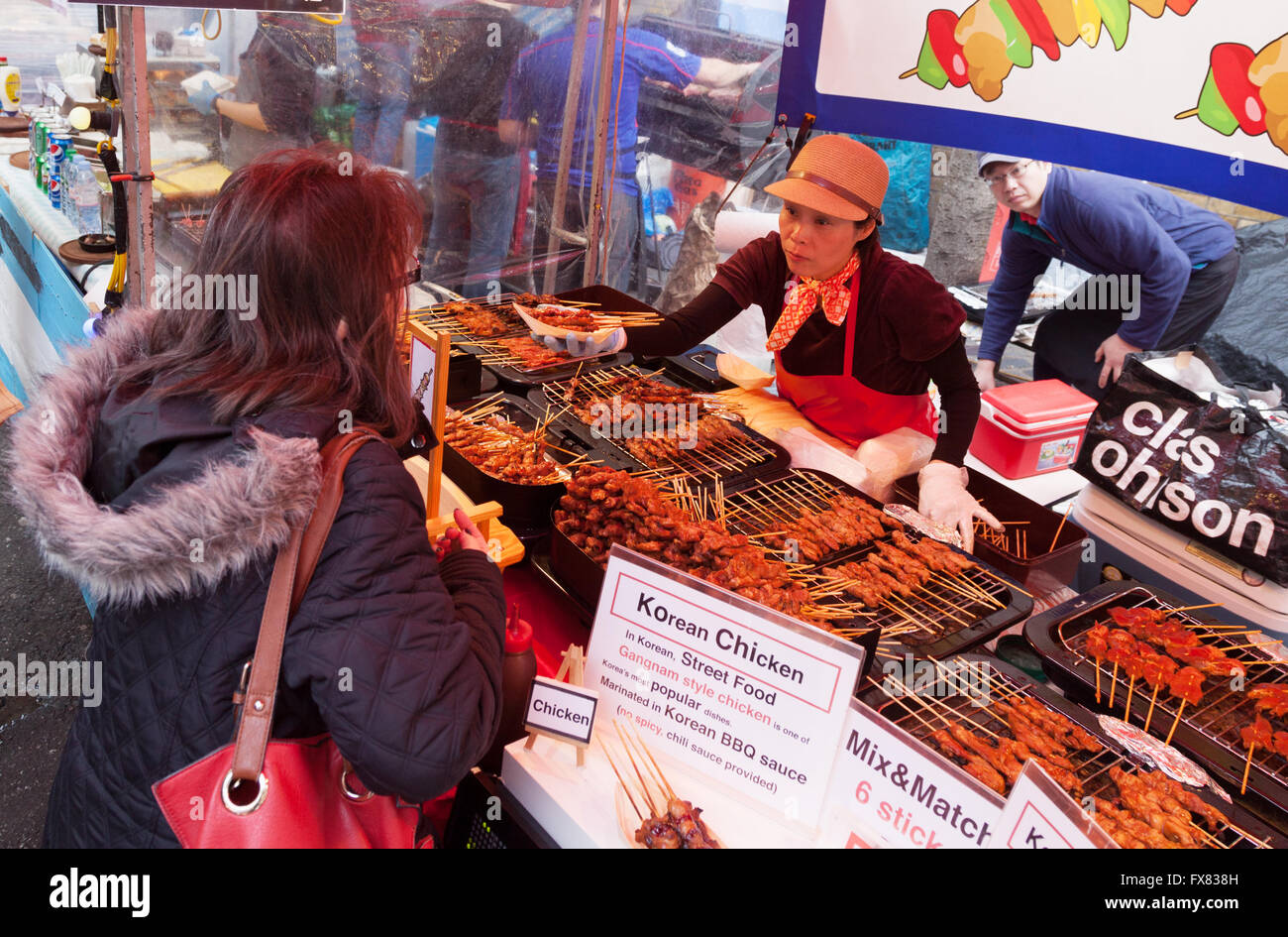 Londra multiculturale; persone ad acquistare cibo Coreano, Brick Lane domenica sistemazione, Brick Lane, Spitalfields, East End, London REGNO UNITO Foto Stock