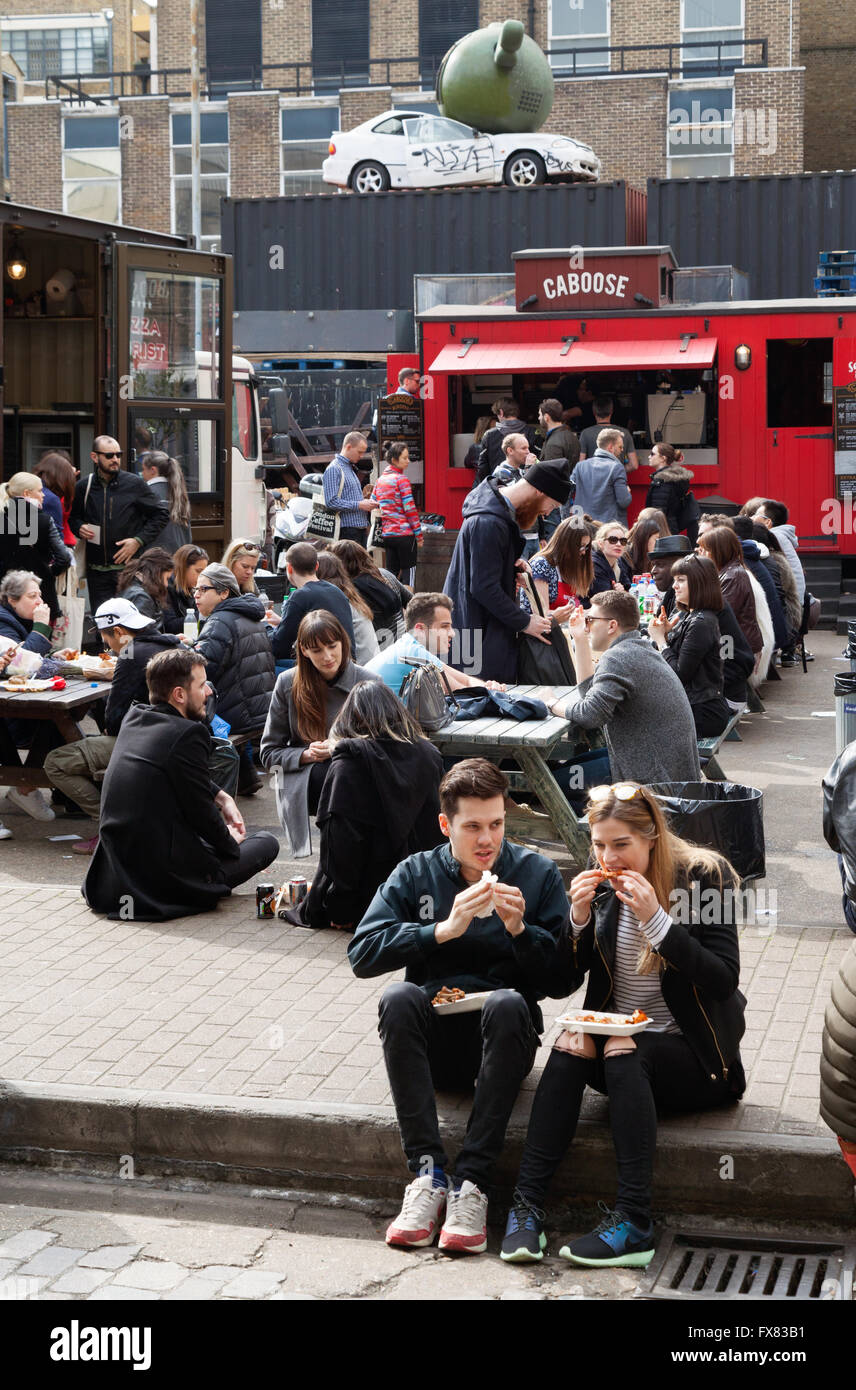 Persone mangiare presso la domenica sistemazione, Brick Lane, Spitalfields, London East End Regno Unito Foto Stock