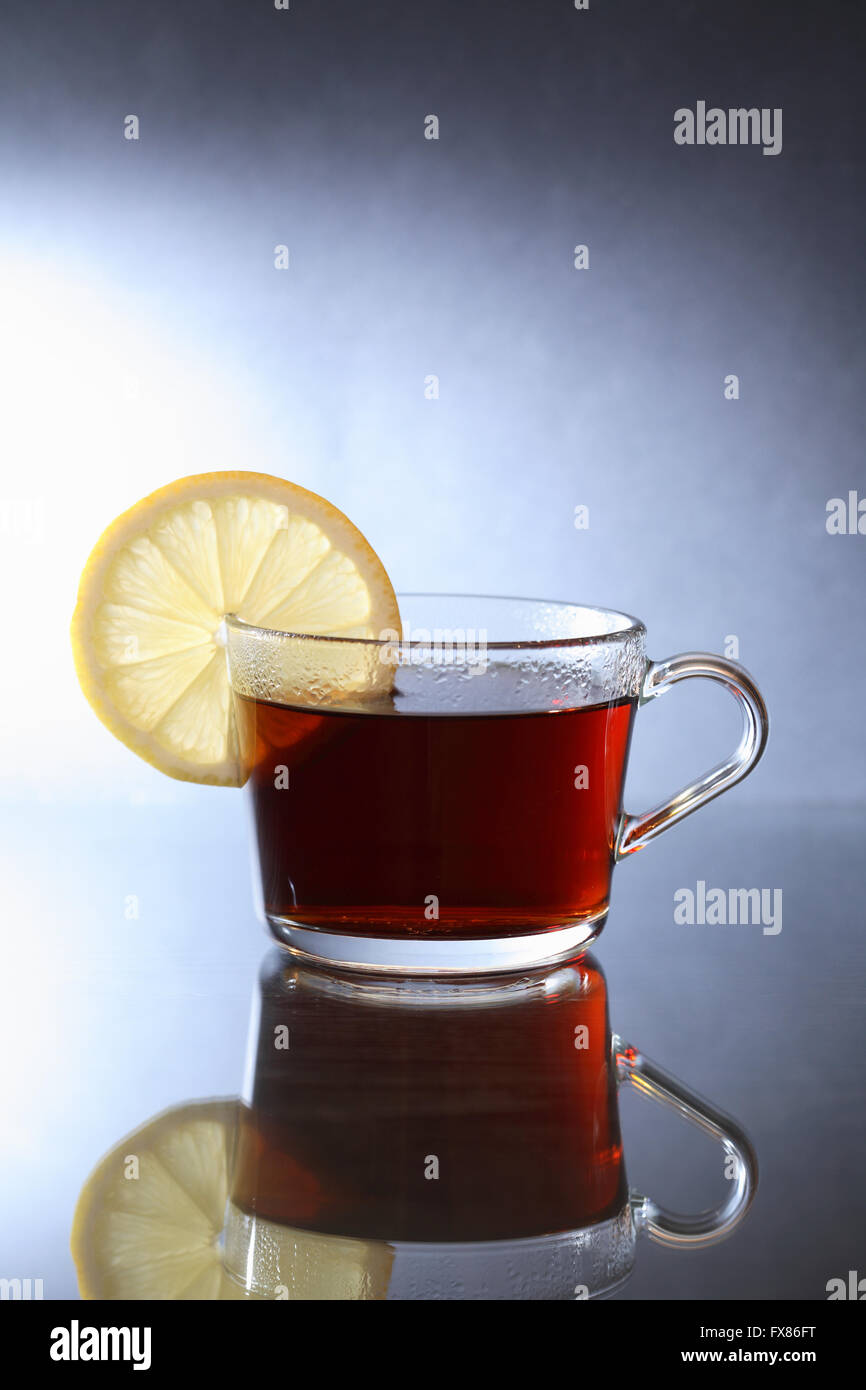 Tazza di tè nero con limone sul bello sfondo scuro Foto Stock