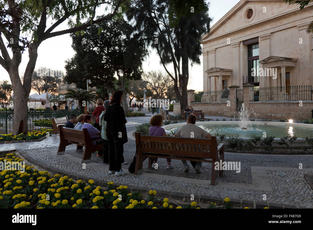 Persone locali e turisti mill circa presso il centro storico di tomaia Barakka Gardens a La Valletta al crepuscolo. Foto Stock