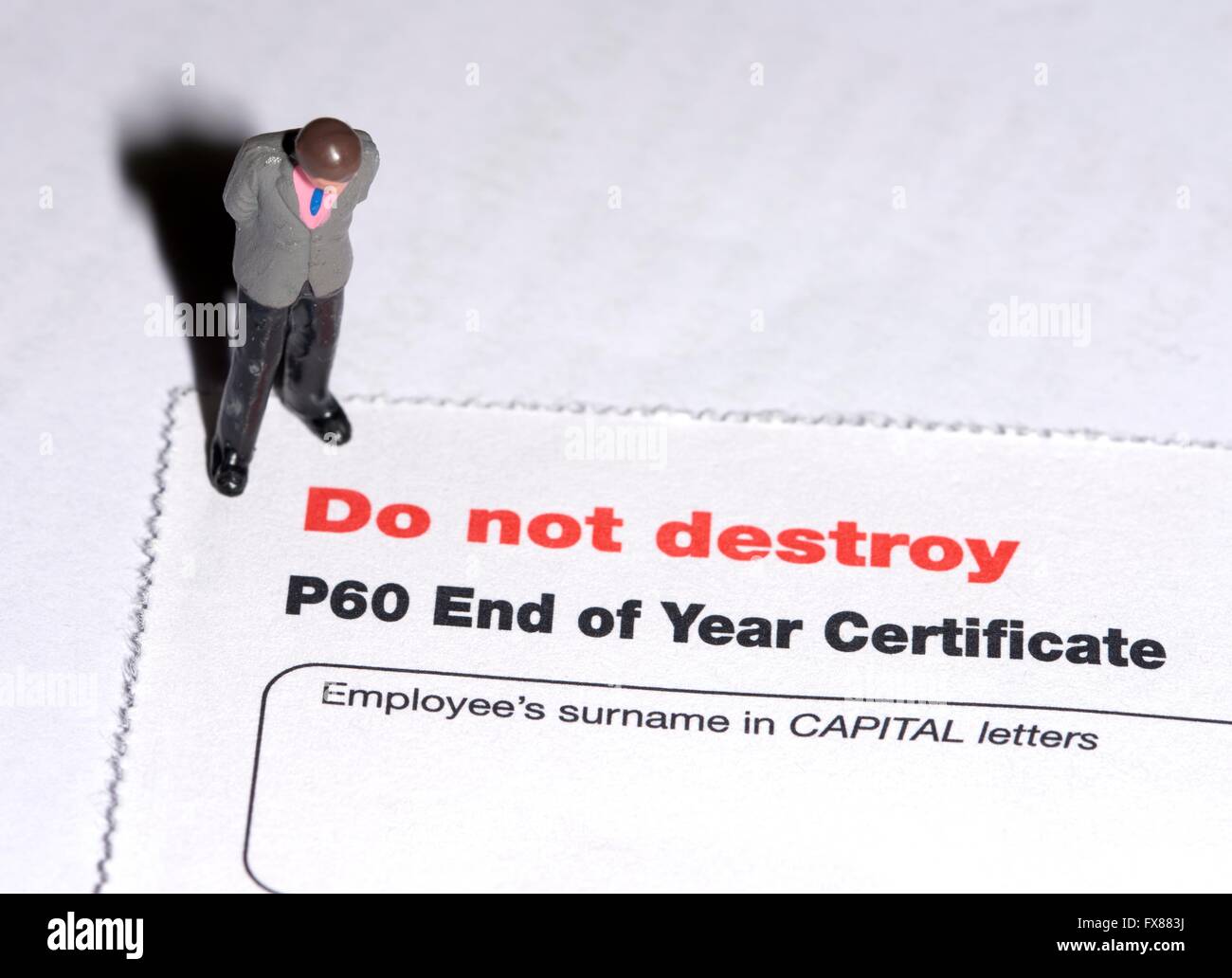 Una statuetta in miniatura uomo in piedi su una P60 di fine anno di certificato fiscale. Foto Stock