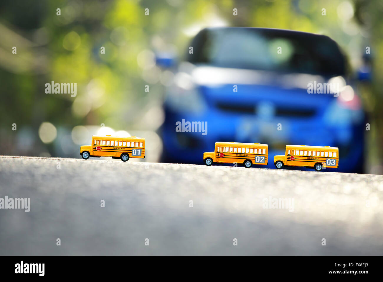 Giallo scuolabus modello giocattolo la strada attraversando.la profondità di campo di una composizione. Foto Stock