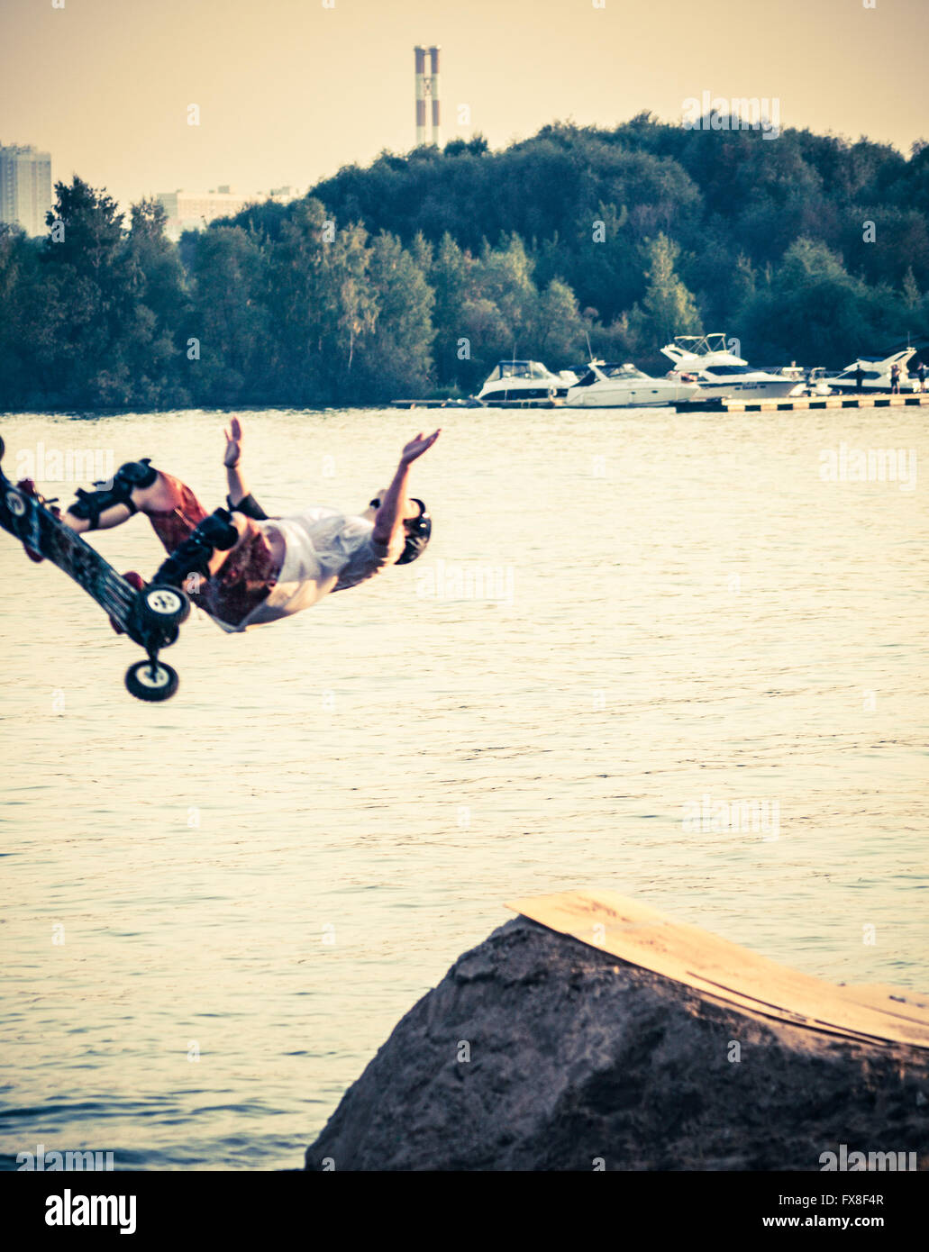 Guidatore di skateboard salti in acqua Foto Stock