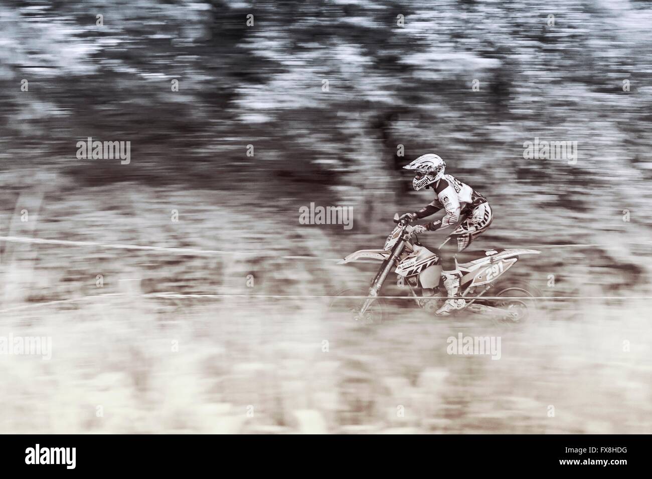 Enduro motociclista accelerando nel fango Foto Stock