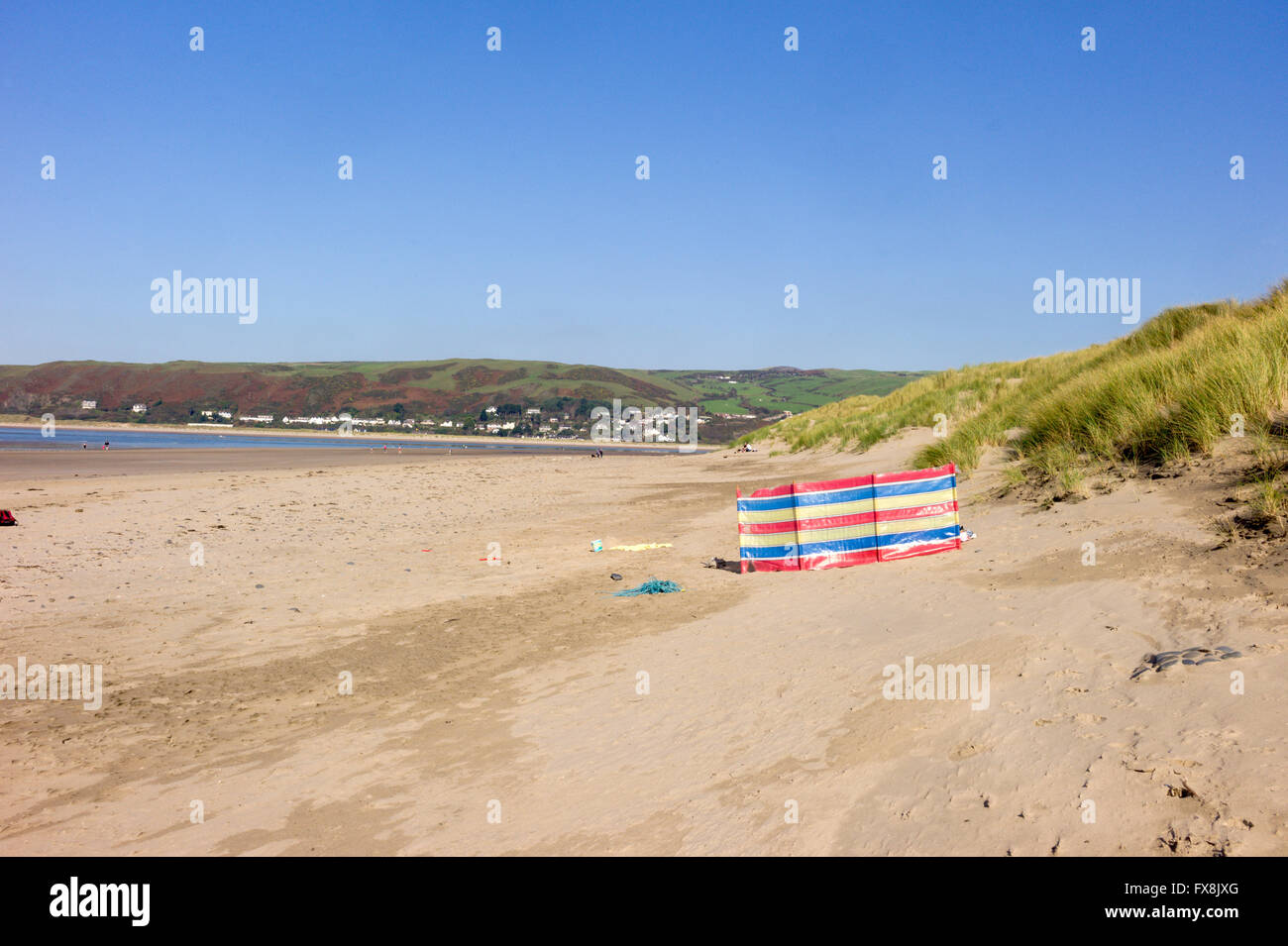 Una pausa di vento eretto sul Ynyslas spiaggia vicino alle dune di sabbia con Aberdyfi village attraverso il Dyfi estuary bocca. Foto Stock