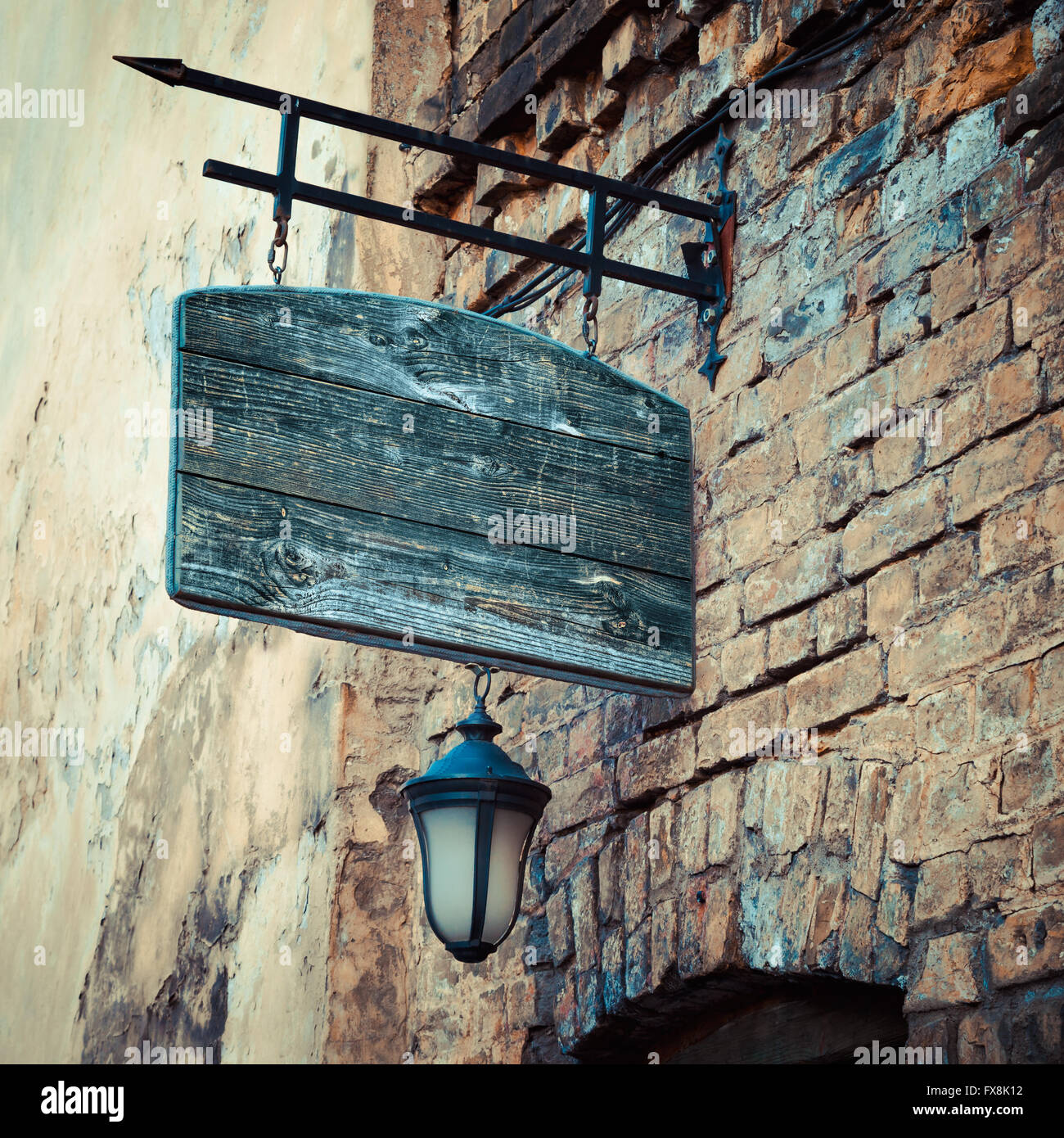 Rustico in legno cartello su di età medievale di parete di mattoni Foto Stock