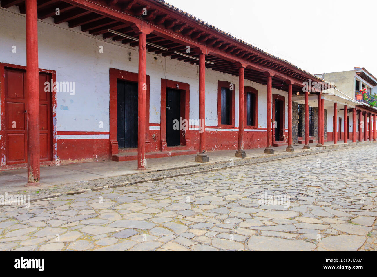 Un vuoto di plaza con una fila di colonne colorate in Tzintzuntzan, Michoacan, Messico Foto Stock