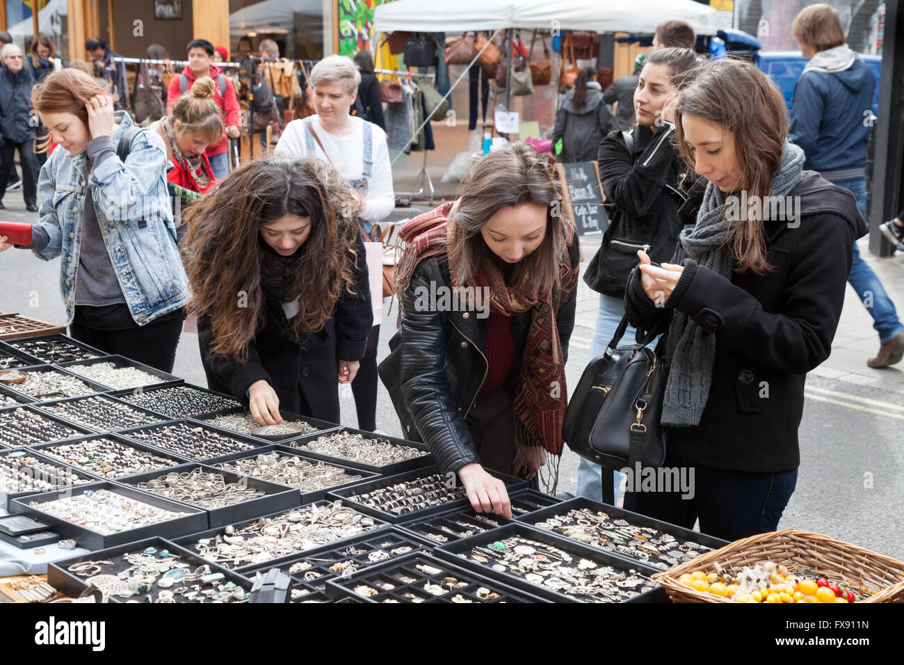 Giovani donne l'acquisto di gioielli a Brick Lane domenica sistemazione, Spitalfields, London East End, Regno Unito Foto Stock