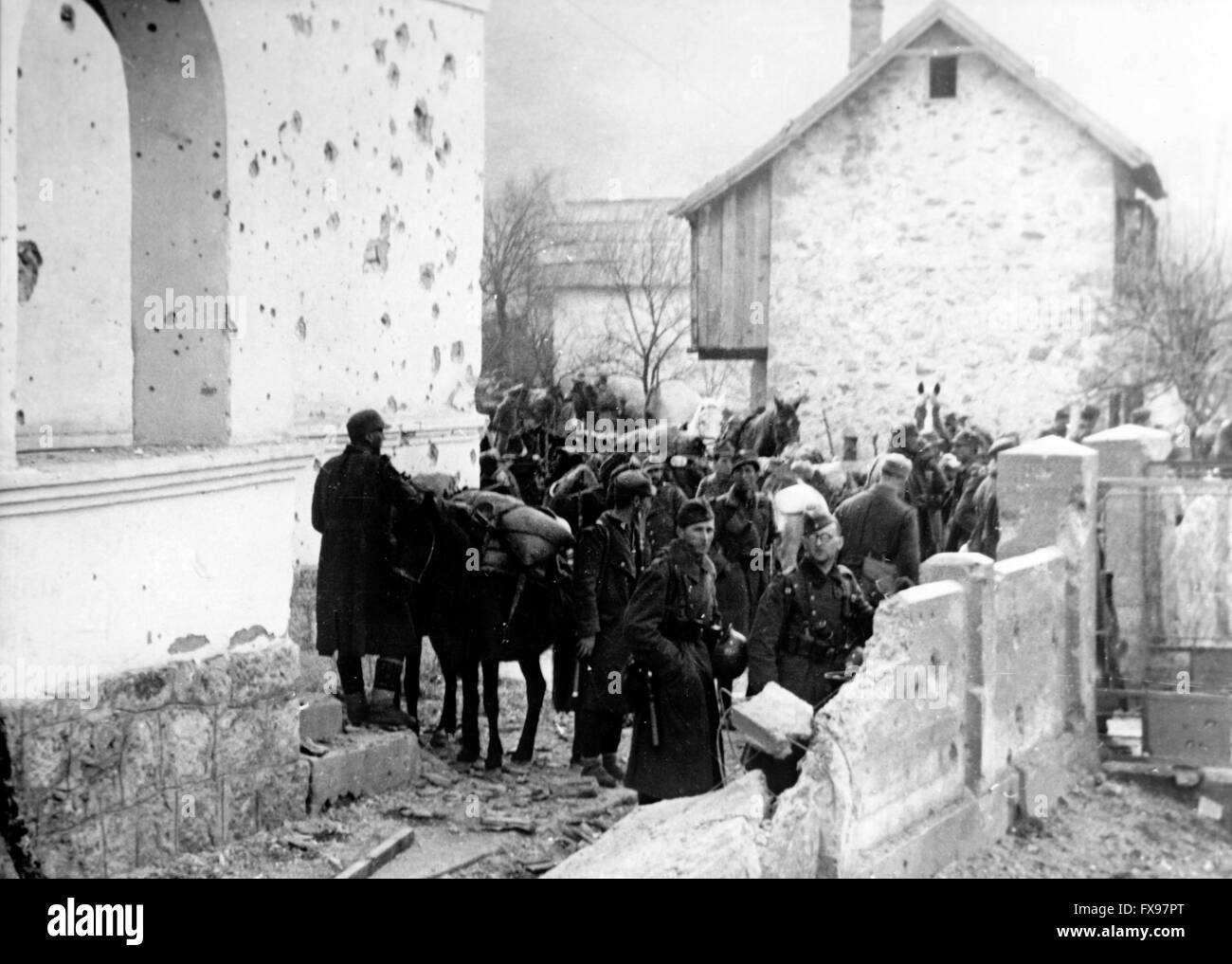 La foto della propaganda nazista mostra i soldati della Wehrmacht tedesca che prendono una pausa dai partigiani combattenti in un piccolo villaggio in Jugoslavia. La foto è stata scattata nell'aprile 1934. Fotoarchiv für Zeitgeschichtee - SENZA FILI - Foto Stock