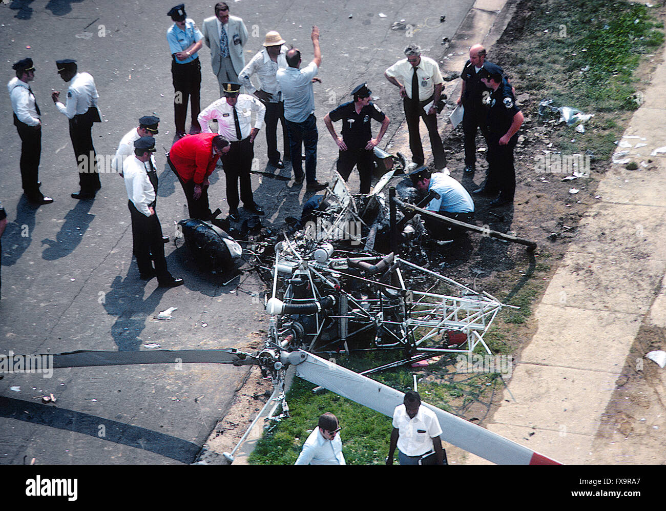 Washington, DC, Stati Uniti d'America, 6 giugno, 1979 funzionari di polizia a fianco del relitto di un elicottero nel blocco 700 di Yuma Street SE. L'imbarcazione si è schiantato e bruciato ieri in maniera restrittiva manca una scuola elementare riempito di quasi mille bambini e un edificio di appartamenti, uccidendo due funzionari di polizia, il pilota Alfred V. Jackson, e l'osservatore, Richard F. Giguere. L'elicottero era una campana 47 modello, un piccolo elicottero in grado di tenere due ufficiali - il pilota e un osservatore - in un abitacolo coperto da una bolla di plastica. Credito: Mark Reinstein Foto Stock