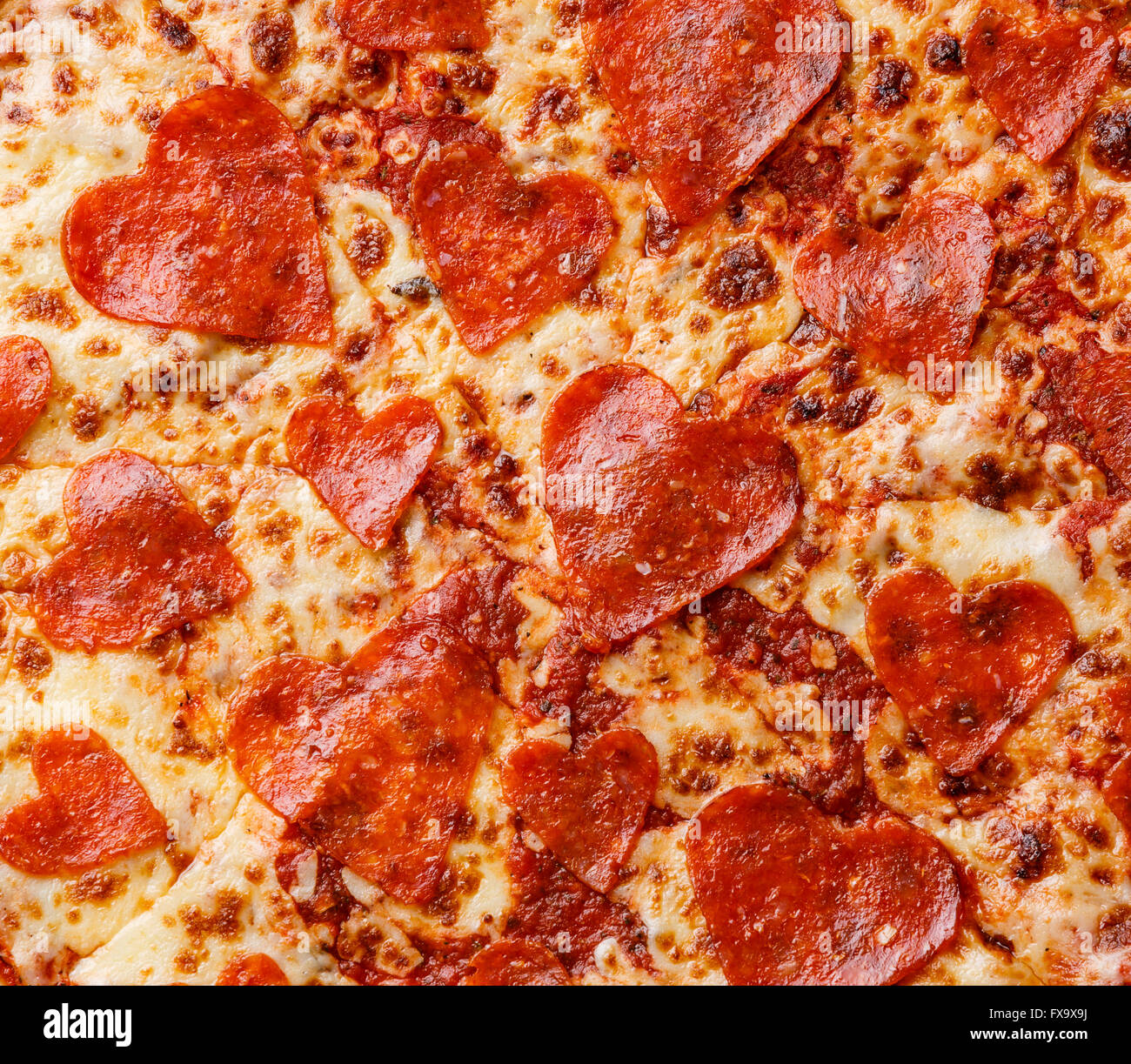 Forma di cuore salsiccia per pizza Pizza close up sullo sfondo Foto Stock