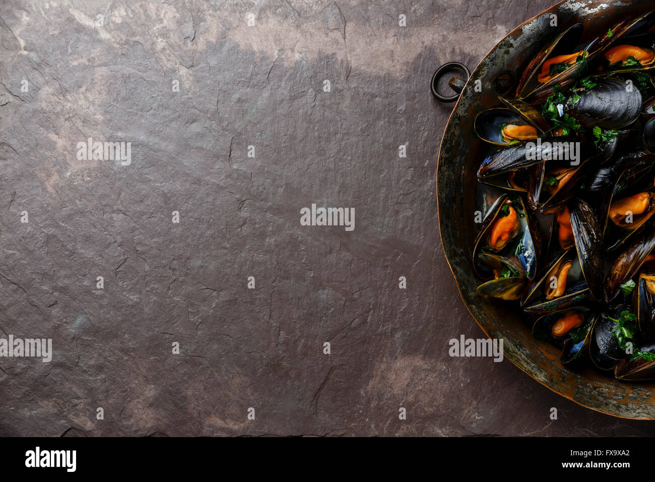 Le cozze con il prezzemolo su pietra ardesia sfondo Foto Stock