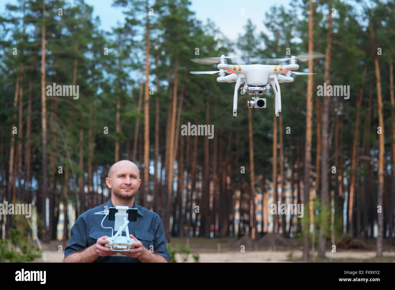 Uomo che utilizza il suo drone outdoor con sfondo di foresta Foto Stock